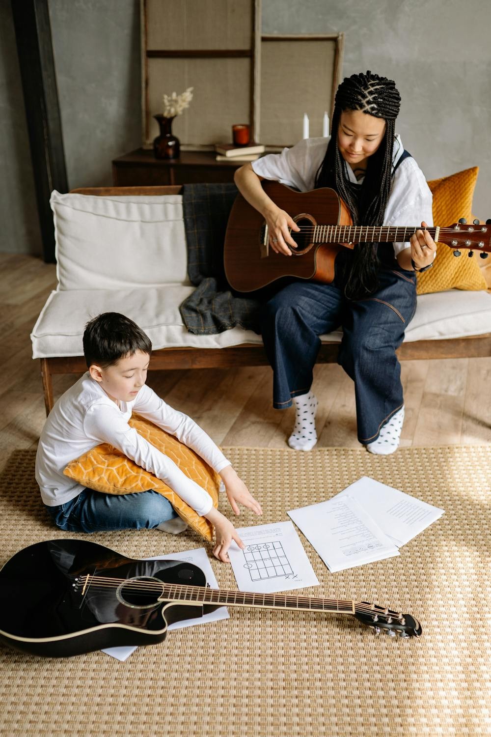 child with a smile holding add guitar
